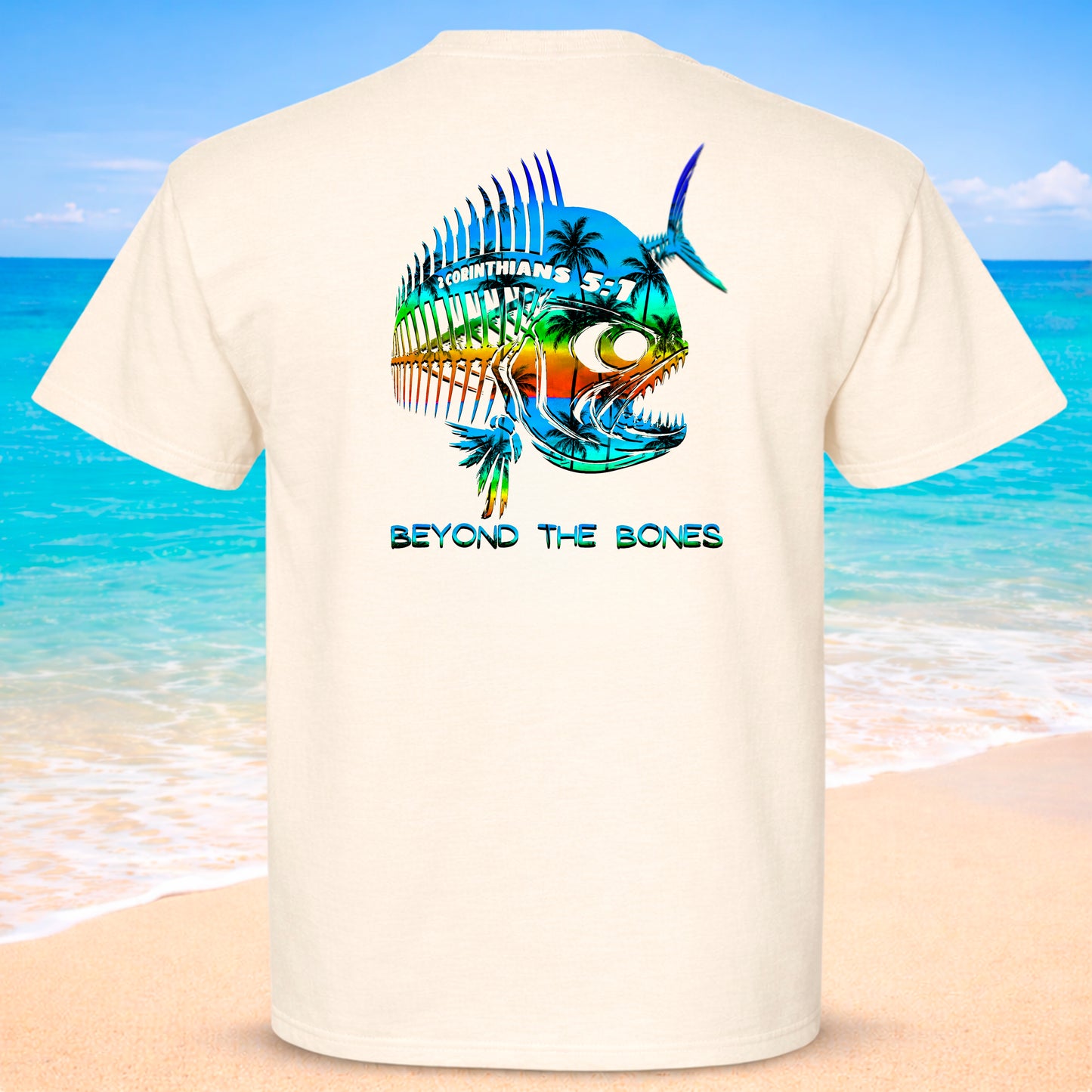 Beige t-shirt with a colorful fish design on the back, set against a beach background.