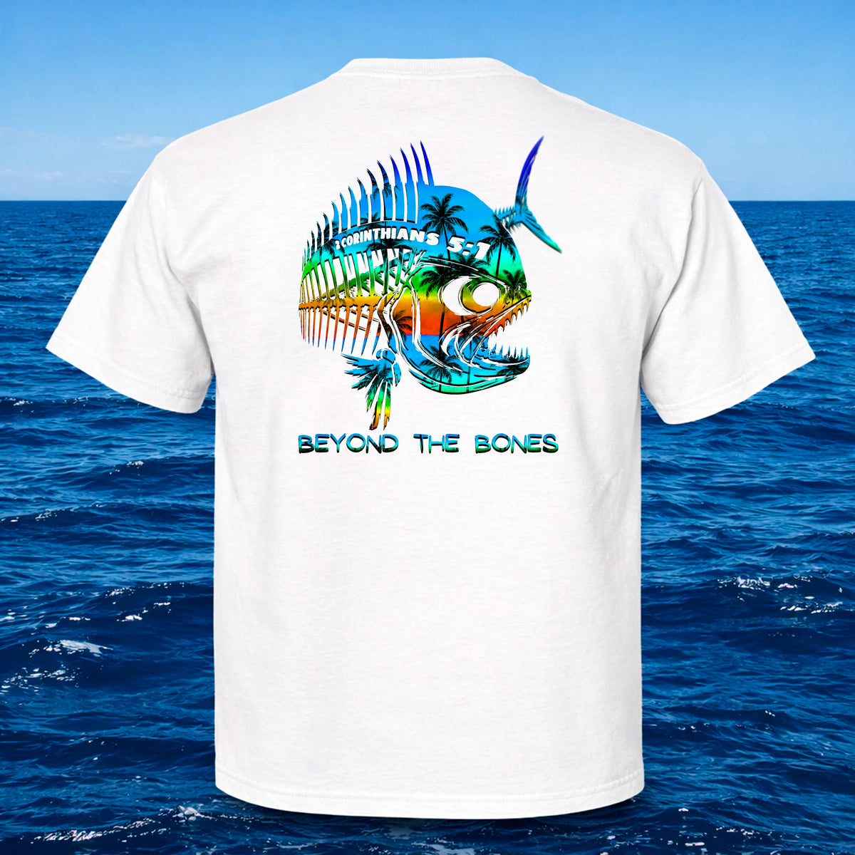 White t-shirt with colorful fish design and 'Beyond the Bones' text against a blue ocean background
