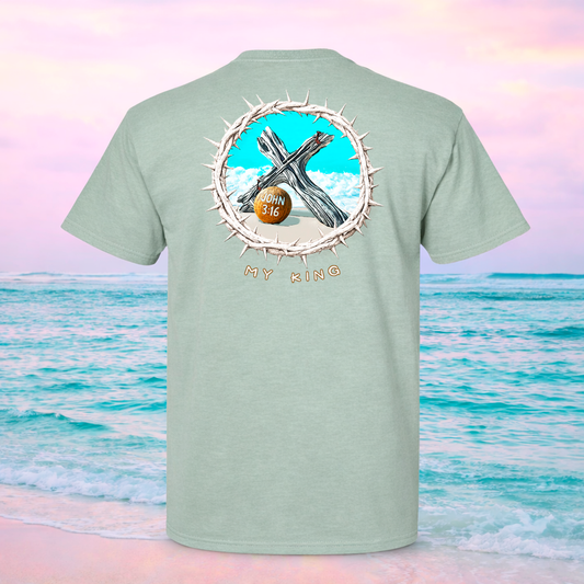 Light green t-shirt with a graphic design on the back, featuring a cross and 'My King' text, against a beach background.