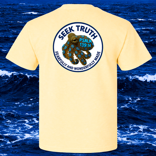 Yellow t-shirt with a Blue Ringed Octopus graphic and text on the back, set against a beach background.