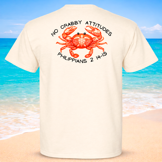 Beige t-shirt with a red crab graphic and text on the back, set against a beach background.