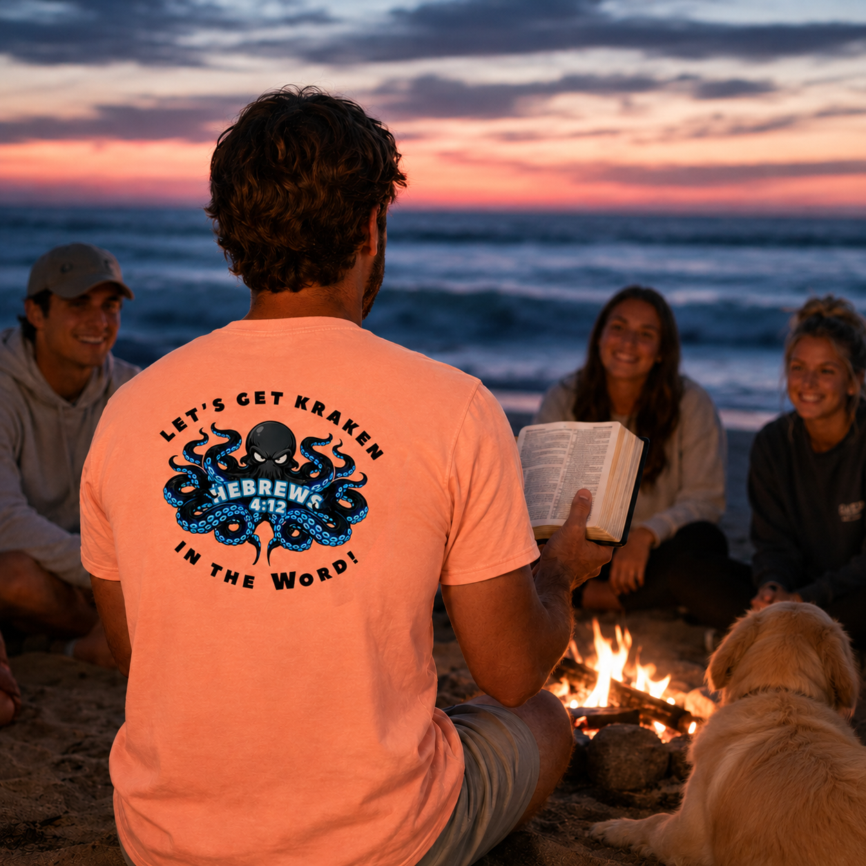 Group of people sitting around a campfire on a beach at sunset, with a person wearing an orange t-shirt with a graphic design.