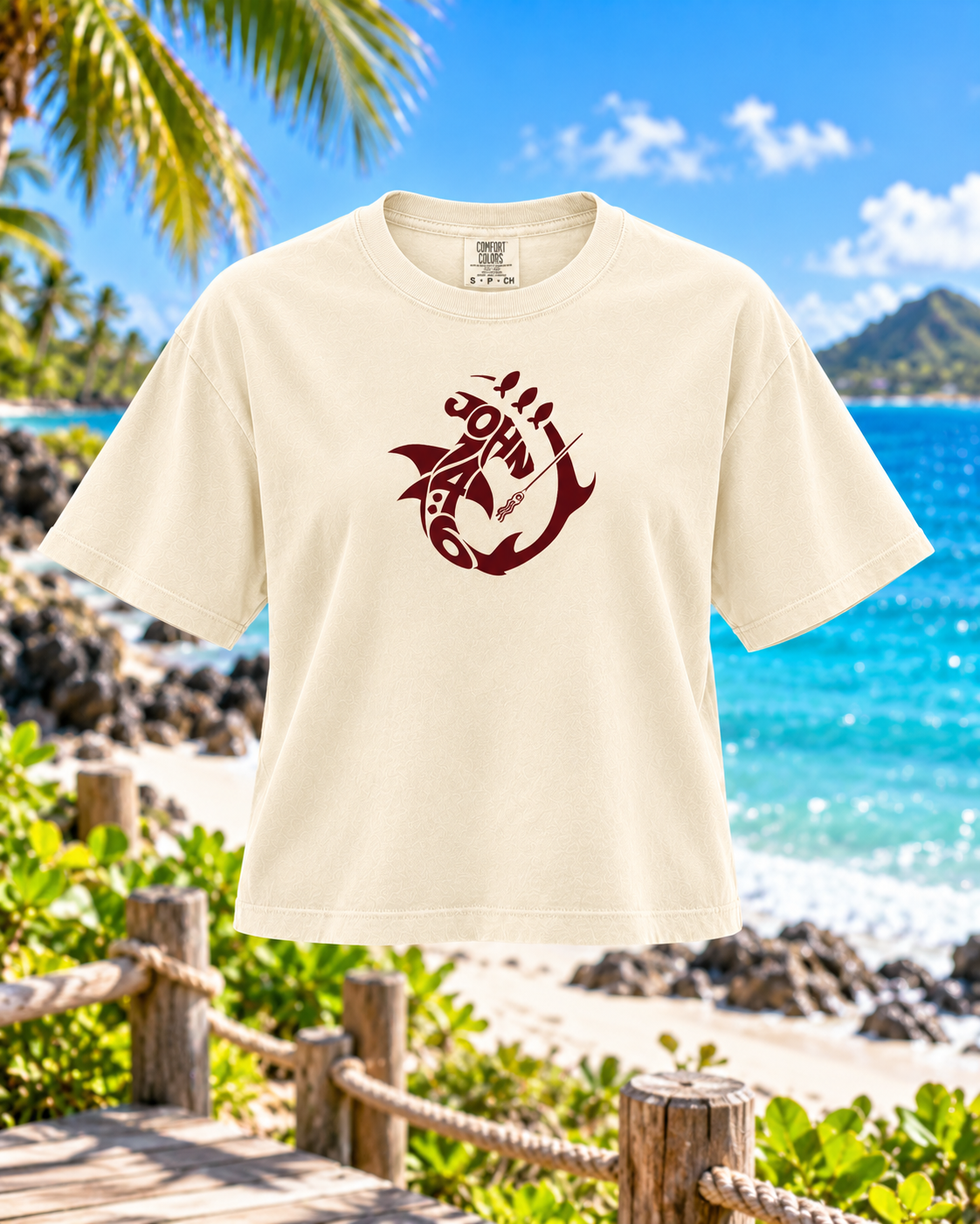 An off-white short-sleeve t-shirt with a dark red graphic of an anchor and a lolo pistol on the chest, displayed against a tropical beach background with palm trees and blue ocean water.
