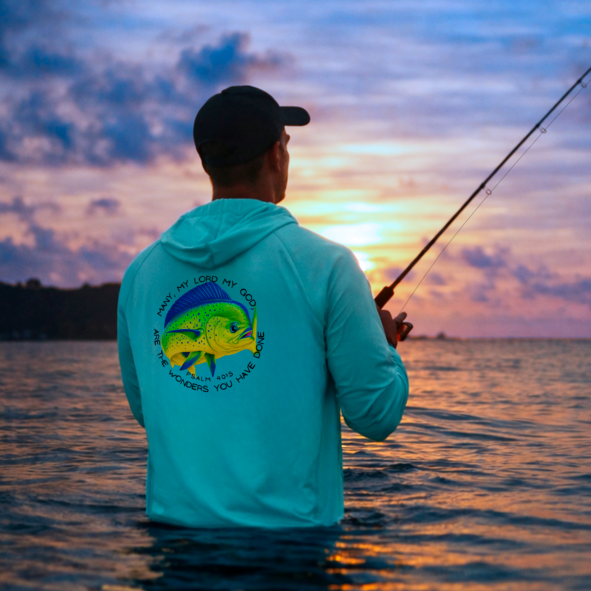 Person fishing at sunset with a colorful Mahi Mahi fish design on their shirt