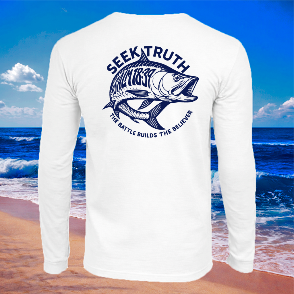 A white long-sleeve t-shirt with a navy blue graphic of a fish and the text 'SEEK TRUTH WITNESS 1939 THE BATTLE BUILDS THE BELIEVER' on the back, shown against a beach and ocean background.